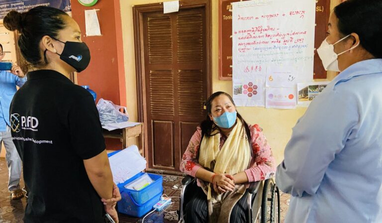 Three women wearing masks having a chat.