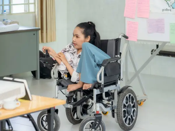 a woman with disabilities sitting on a motorized wheelchair.