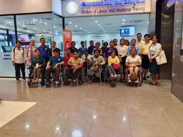 a group of people including those with disabilities posing for the camera.