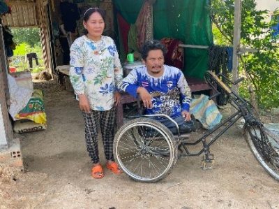 Mr Soeun Da is sitting in an adapted wheelchair, his mother is standing next to him.