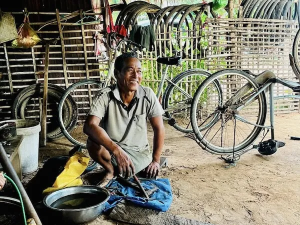 Man with disability seated in his bicycle repair shop.