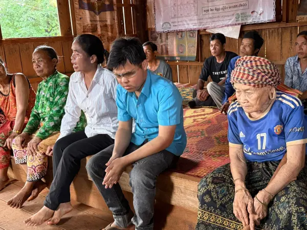 a group of people sitting on a raised platform listening to an exchange.