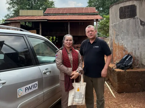 a woman and a man standing next to a car.