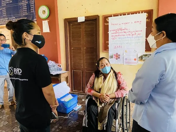 Three women wearing masks having a chat.