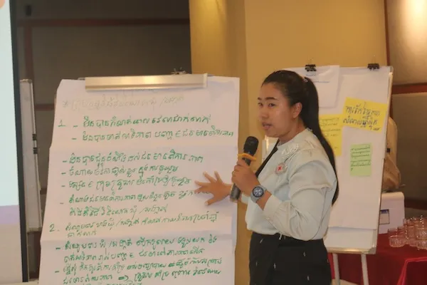 a woman explaining training materials on white paper