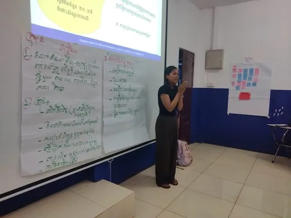 a woman standing in front of a slide presentation