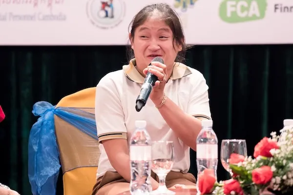 a woman speaking to a microphone